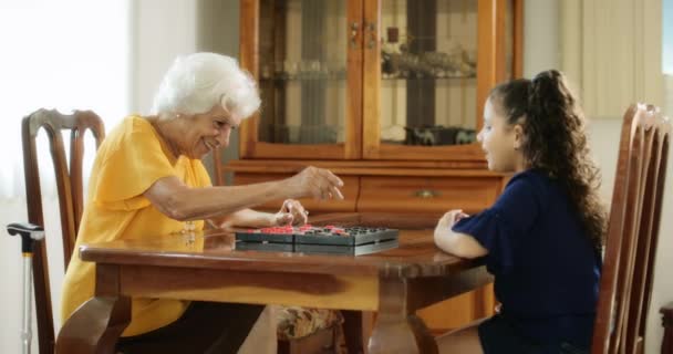 Senior Woman And Little Girl Playing Checkers Board Game — Stock Video