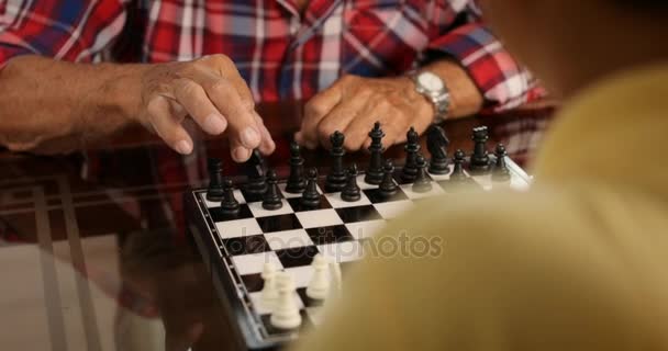 Hombre mayor y niño pequeño jugando al ajedrez Juego de mesa — Vídeos de Stock