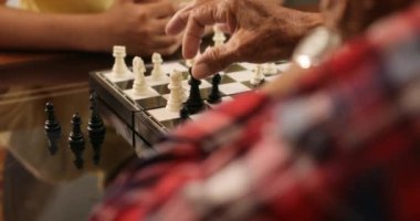 Büyükbaba evde torunu ile satranç masa oyunu oynamak