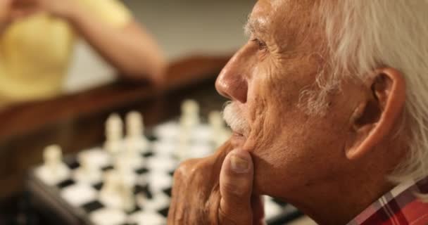 Дедушка играет в шахматы Настольная игра с внуком дома — стоковое видео