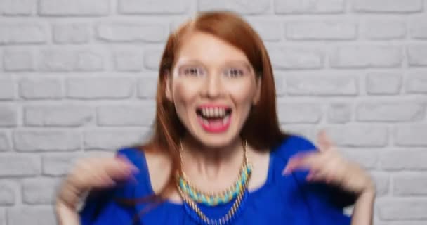 Výrazy obličeje mladé Zrzky ženy na cihlové zdi — Stock video