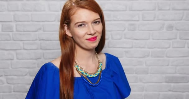 Gesichtsausdruck der jungen rothaarigen Frau auf Ziegelmauer — Stockvideo