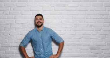Genç sakallı adam tuğla duvar yüz ifadeleri