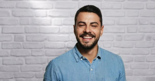 Expresiones faciales de joven barba hombre en la pared de ladrillo — Vídeo de stock