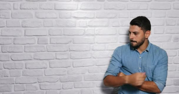 Expresiones faciales de joven barba hombre en la pared de ladrillo — Vídeo de stock