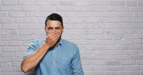 Výrazy obličeje mladých vousy člověka na cihlové zdi — Stock video