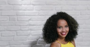 Genç siyah kadın tuğla duvar yüz ifadeleri