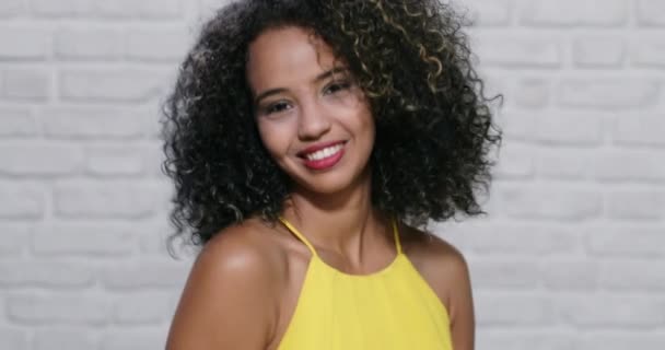 Expresiones faciales de la joven mujer negra en la pared de ladrillo — Vídeos de Stock