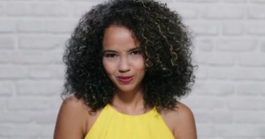 Genç siyah kadın tuğla duvar yüz ifadeleri