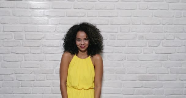 Міміки молода чорна жінка на цегляна стіна — стокове відео