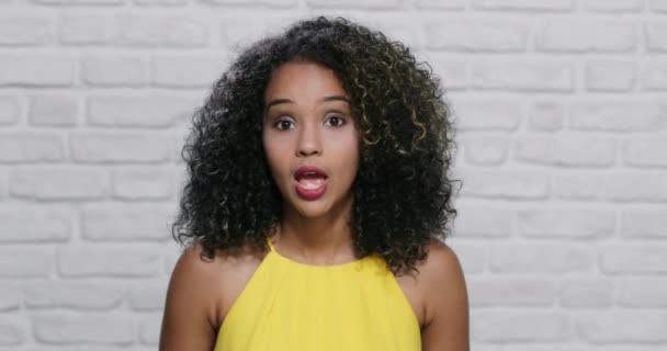Εκφράσεις του προσώπου νεαρή μαύρη γυναίκα σε τοίχο από τούβλα — Αρχείο Βίντεο