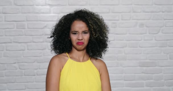 Mimika młody czarny kobieta na ceglany mur — Wideo stockowe