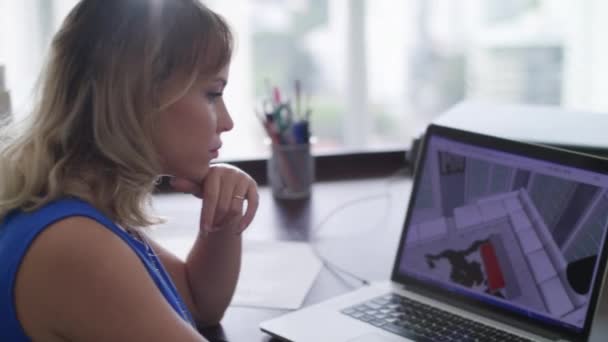 Женщина, работающая архитектором, делает 3D-рендер на компьютере — стоковое видео
