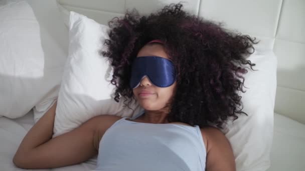 Müdes schwarzes Mädchen wacht mit Schlafmaske im Bett auf — Stockvideo