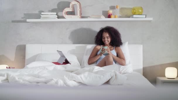 Mulher bebendo café assistindo filme na cama no domingo — Vídeo de Stock