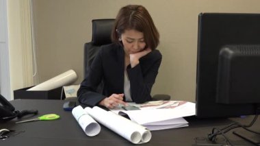 Asya insanlar tatilinde ofiste rahatlatıcı. Japon iş kadın yazarak kısa mesaj cep telefonu sesleri sıkılmış. Yorgun işkadını smartphone ile e-posta gönderme