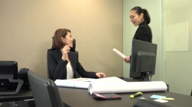 Ofiste çalışan Asya insanlar. Japon iş kadınları Studio projeleri ile çalışma. Sekreteriyle konuşurken ve planları toplantı sırasında seyir emin işkadını