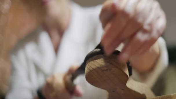 スペイン人女性は店でルートメーカーとして働いています ワークショップやキャスタネット作り スペインのフラメンコ伝統音楽のための楽器で働く女性 手綱で手を閉じて — ストック動画