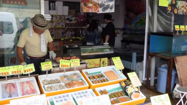 日本Hakodate 2019年7月 日本人在日本北海道Hakodate Asaichi 晨间市场 的海鲜和食品商店工作 店主在厨房的烤架上煮螃蟹 — 图库视频影像
