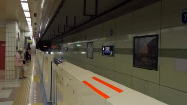 Sapporo / Japonya - Temmuz 2019: Sapporo, Hokkaido, Japonya, Asya 'daki metro istasyonuna giden metro treni. Platformda bekleyen Japonlar ve yoğun saatlerde seyahat eden Asyalı banliyö sakinleri