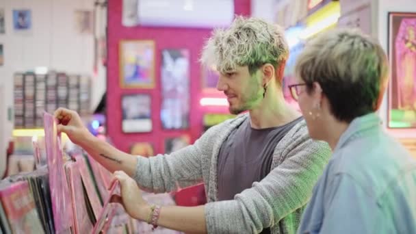 Casal jovem escolhendo Vintage LP de vinil na loja de discos — Vídeo de Stock