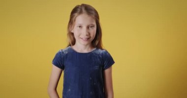 Kameraya bakıp gülümseyen beyaz bir kızın portresi. Duyguları ve neşe duyguları olan kızıl saçlı bir kadın çocuk. Boşluğu kopyala, yavaş çekim