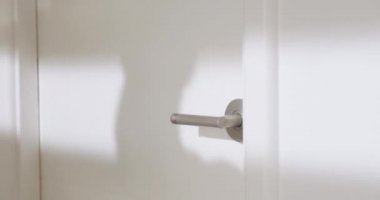 Kişi eli, tuvalet için kapı koluna dokunurken kağıt mendil kullanırken yakın çekim görüntüsü. İnsanlar tuvaletteki virüs ve mikroplardan kaçınmak için önlem alıyorlar. Sağlık hizmetleri için ıslak mendil tutan kadın