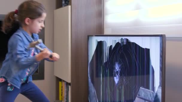 マッドの女の子ハンマーでLcdテレビセット画面をスマッシング クレイジー女性の子供は激怒と暴力のためのツールでテレビモニターを打つ — ストック動画