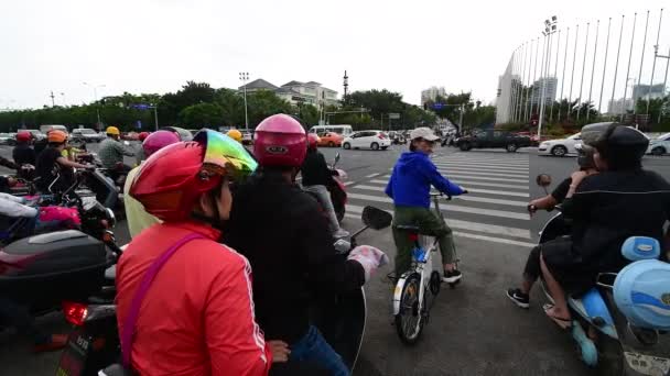 Санья, Китай - 11 декабря 2019 года: 4K видео, где электрические скутеры пересекают улицу — стоковое видео