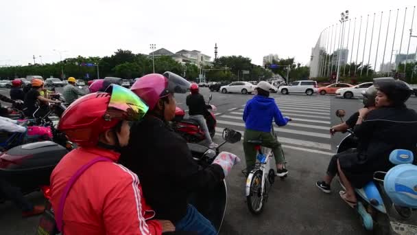 Sanya, China - 11 de diciembre de 2019: 4K video de Scooters eléctricos cruzando la calle — Vídeo de stock