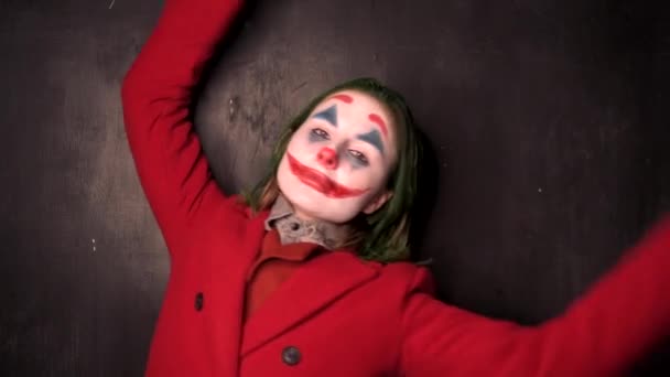 Femme portant un manteau rouge avec un clown cosplay maquillage — Video