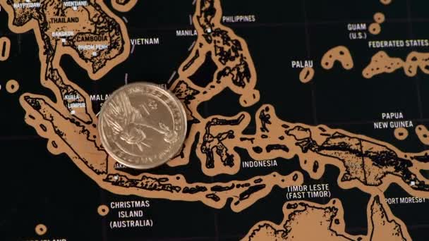 One dollar coin on black scratch travel map of Malaysia, Singapore — Stock Video