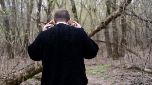 Hombre de pie junto a un bosque con máscara médica negra de coronavirus covid-19 — Vídeos de Stock