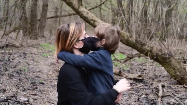 Donna e figlio in piedi nella foresta in maschera medica nera dal virus Covid-19 — Video Stock