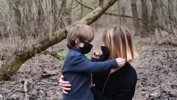 Mulher e filho em pé na floresta com máscara médica preta do vírus Covid-19 — Vídeo de Stock