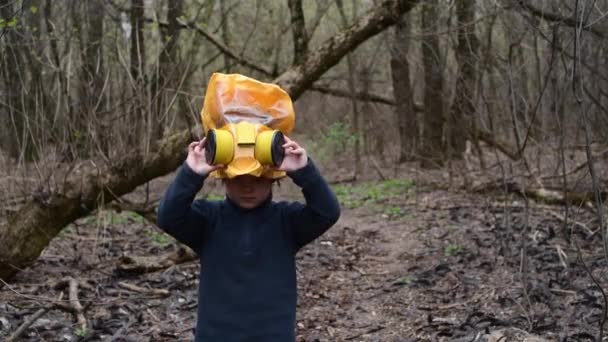 若いです男の子4歳で森の中で身に着けています黄色疫学マスクからCovid-19ウイルス — ストック動画
