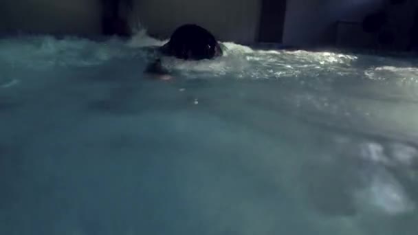 Профессиональный триатлонист плавает в бассейне. тренировки по триатлону — стоковое видео