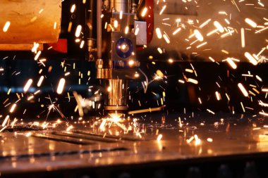  Endüstriyel lazer kalın bir metal tabakayı keser. Erimiş metal her yöne dağılır.