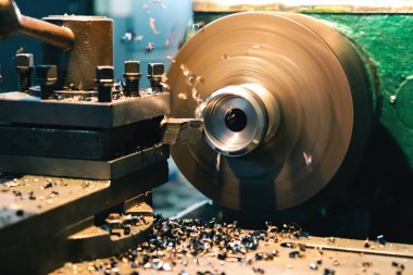 Eski usul torna bir parçayı öğütür ve talaşlar işlevinden farklı yönlere uçar. Eski torna.