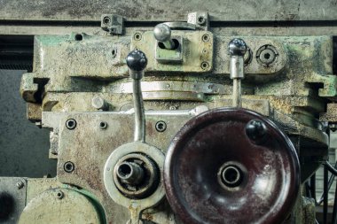 Eski, paslı bir değirmen makinesi, geri dönüşüm sırasının gelmesini bekliyor.