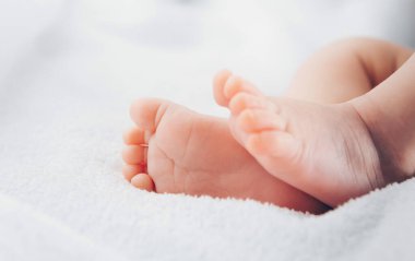Yumuşak beyaz battaniyede yeni doğmuş ayaklar