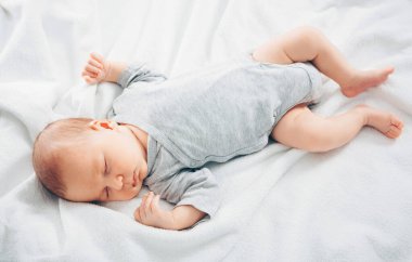Yeni doğan bebek beyaz ekose üzerinde uyur