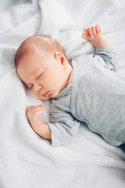 uyuyan yeni doğmuş erkek bebek yatakta.