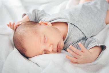 Uyuyan yeni doğmuş erkek bebek yatakta, portre