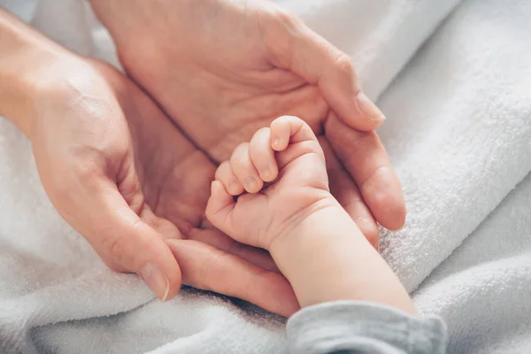 Primer plano mano del bebé en las manos de las madres — Foto de Stock