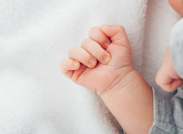 Recién nacido babys mano primer plano en manta blanca — Foto de Stock