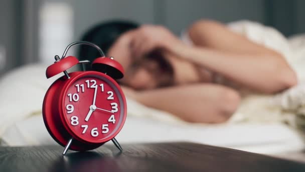 Женщина просыпается, выключает будильник и продолжает спать. — стоковое видео