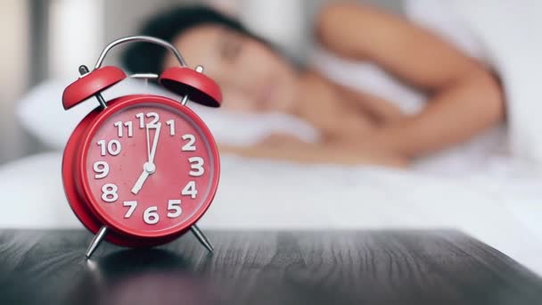 Güzel kız yatakta uyur, çalar saati kapatır ve uyumaya devam eder. Alarm saatine odaklan — Stok video