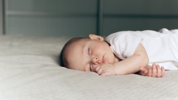 Dormir mignon bébé garçon sur couverture grise — Video