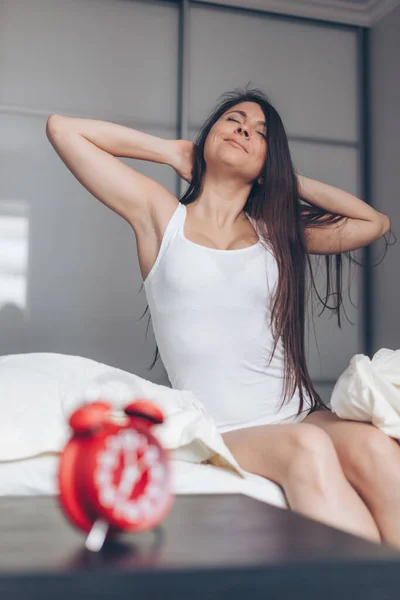 Bela feliz jovem mulher acordar de manhã e alongamento na cama — Fotografia de Stock